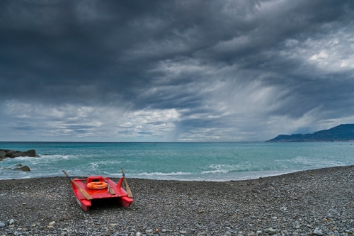 Immagine con nuvole, mare, spiaggia, acqua, remi, rosso, pattino, cielo, salvagente, barca, pietre, colori, ghiaia, sabbia, pedalò